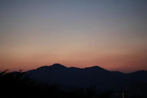 シルエットの山と茜色の朝焼けの空の風景 シルエット,山,茜色の写真素材