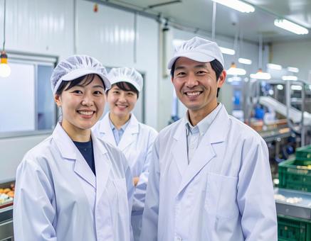 食品工場で制服姿で笑顔の男女の作業員 食品工場で制服姿で笑顔の男女の作業員の写真