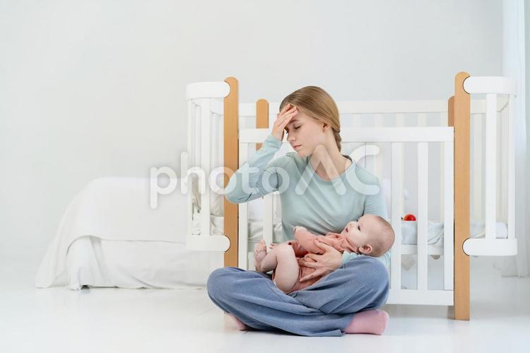 赤ちゃんを抱き頭痛の女性 女性,赤ちゃん,かわいいの写真素材