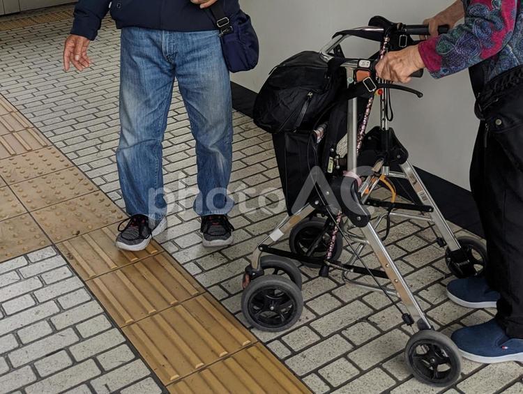 駅で手押し車を押して歩く高齢者と介助者 高齢者,後期高齢者,介護の写真素材