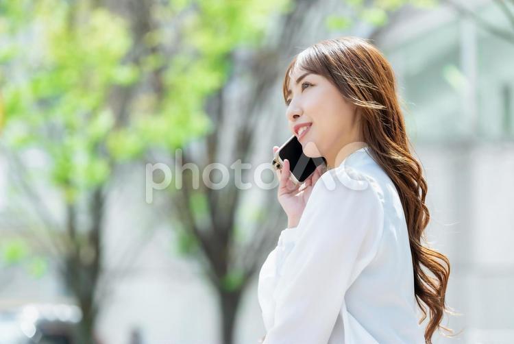 スマホで通話をするビジネスウーマンの横顔 女性,ビジネス,ビジネスウーマンの写真素材
