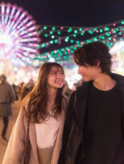 観覧車の光に照らされた二人の写真