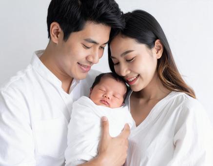 赤ちゃんを抱く幸せそうな夫婦 赤ちゃんを抱く幸せそうな夫婦の写真
