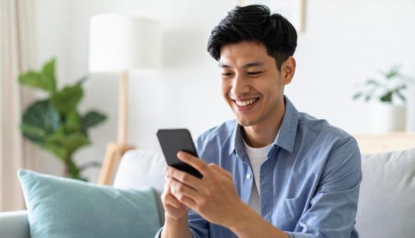 スマートフォンを見て微笑むポートレート スマートフォンを見て微笑むポートレートの写真