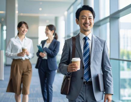 オフィスの廊下で談笑するビジネスパーソンの写真