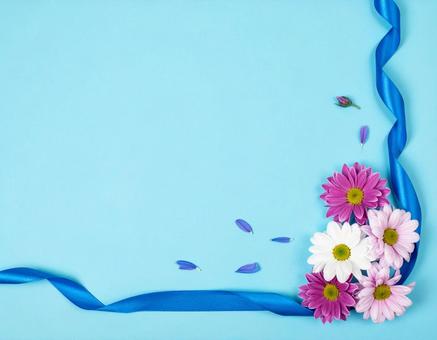 水色背景に花と青いリボン 水色背景に花と青いリボンの写真