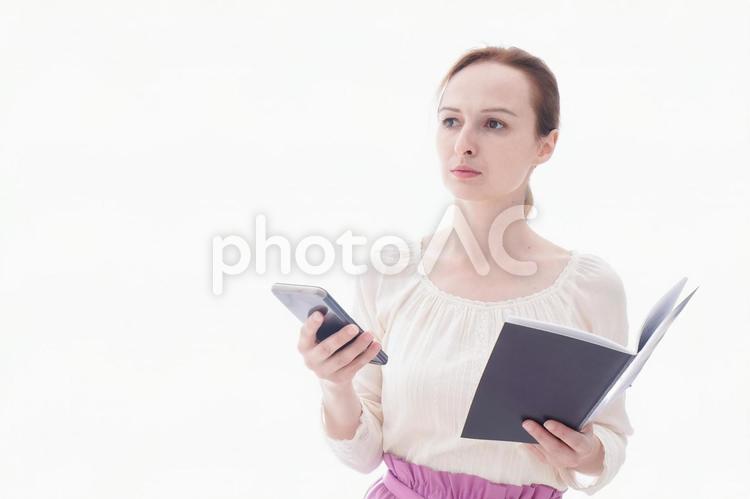 スマホアプリを使う笑顔の若い女性 地図,メール,ワーホリの写真素材
