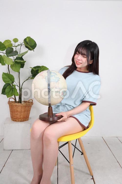 部屋着で地球儀を回して遊ぶ女性 女性,若い,20代の写真素材