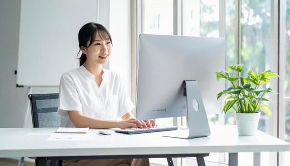 パソコンに向かって話す女性 パソコンに向かって話す女性の写真