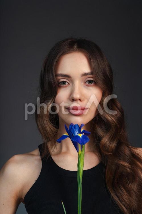 青い花を持ちカメラ目線の女性 女性,花,菖蒲の写真素材