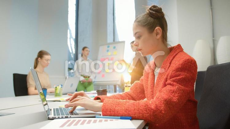 ノートパソコンを使っている女性と同僚 ビジネス,ビジネスマン,ビジネスウーマンの写真素材
