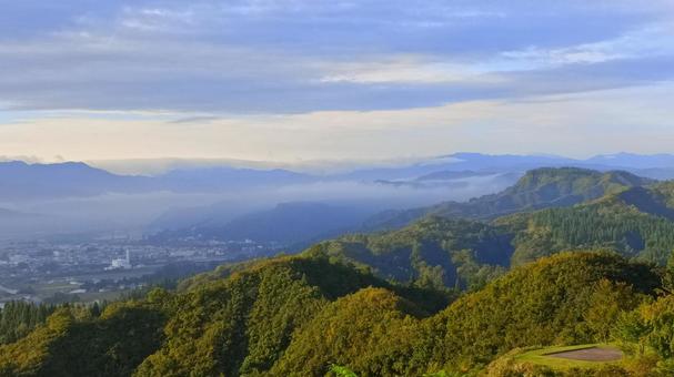 朝の山から下の街を見下ろした風景 朝の山から下の街を見下ろした風景の写真