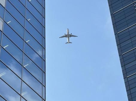 ビルの間を飛ぶ飛行機 ビルの間を飛ぶ飛行機 飛行機,旅客機,ビルの写真素材