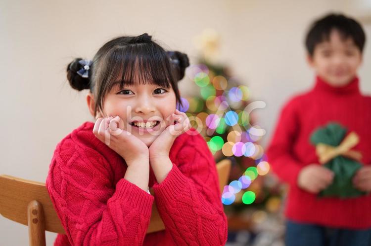 カメラ目線で頬杖をする赤い服の女の子 女の子,頬杖,笑顔の写真素材