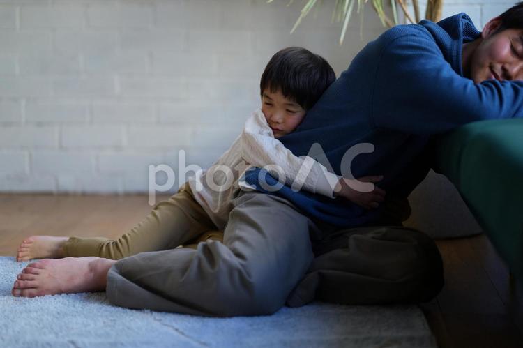 裸足で男性に抱きついて寝ている男の子 親子,男の子,小学生の写真素材