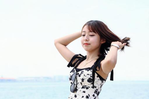 潮風に髪をなびかせる女性 潮風に髪をなびかせる女性の写真