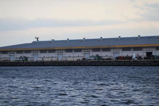 青い海面の海と海岸の倉庫のある空の風景 青い海面の海と海岸の倉庫のある空の風景の写真