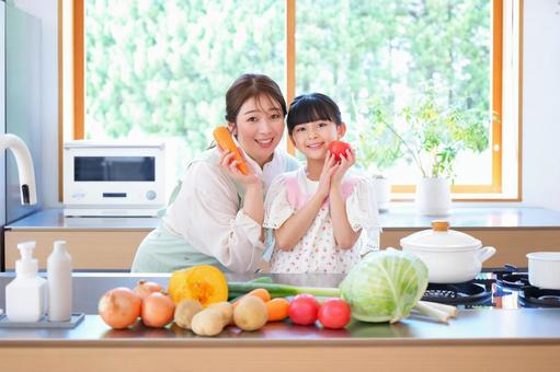 カメラ目線で野菜を持つ親子 カメラ目線で野菜を持つ親子の写真