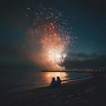 夜の海に映る鮮やかな花火と夏祭りの情景 夜の海に映る鮮やかな花火と夏祭りの情景の写真