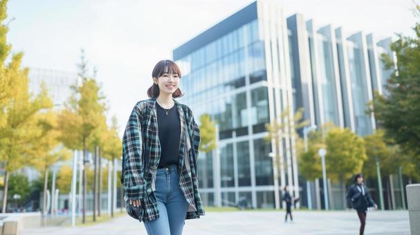 大学のキャンパスに立つ私服の女子学生 大学のキャンパスに立つ私服の女子学生の写真