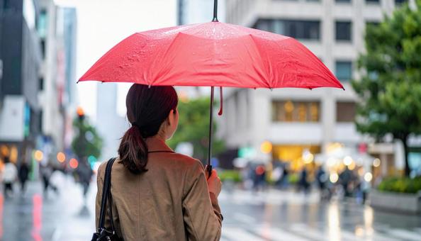赤い傘をさして歩く女性の後ろ姿 赤い傘をさして歩く女性の後ろ姿の写真