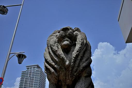 青空の都会の前に勇ましく立つ像 石像,都会,ビルの写真素材