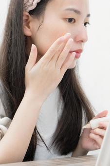 ファンデーションを塗る女性 女性,ファンデーション,化粧下地の写真素材