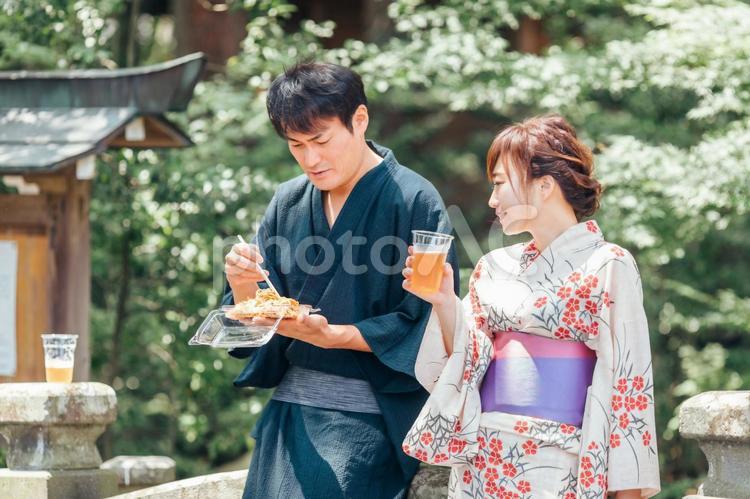 夏祭りにきてビールや焼きそばを食べる男女 夏祭り,縁日,たこ焼きの写真素材
