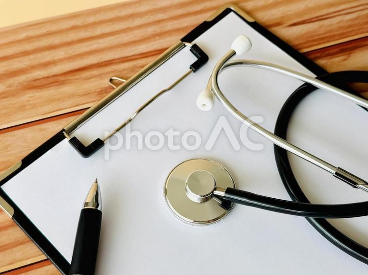 机の上に置かれたクリップボードと聴診器 聴診器,カルテ,クリップボードの写真素材