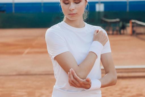 肩肘をさする女性の写真