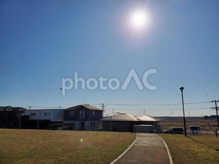 太陽に照らされた家並みと続く道 太陽,空,道の写真素材