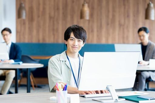 オフィスで働く若いビジネスマン オフィスで働く若いビジネスマン ビジネスマン,笑顔,オフィスの写真素材