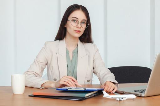 眼鏡をかけたカメラ目線の女性スタッフ 保険業,事務職,接客業の写真素材