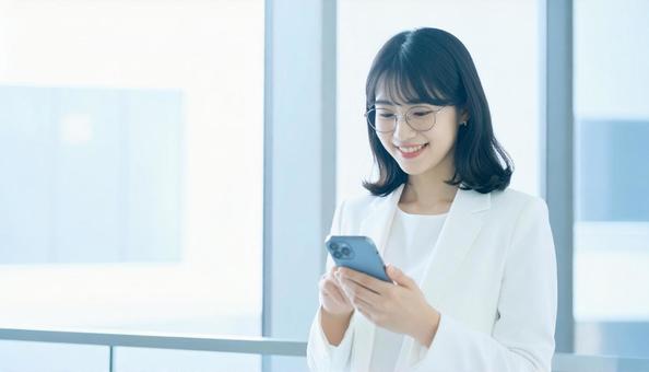 スマホを確認するビジネス女性 スマホを確認するビジネス女性の写真