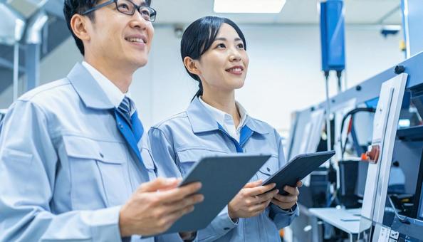 工場でタブレットで製品を検査する作業員 工場でタブレットで製品を検査する作業員の写真