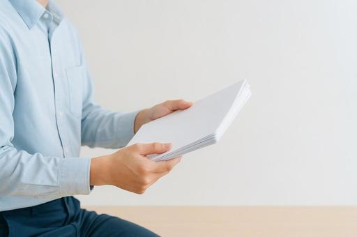 書類を持つ手のクローズアップの写真