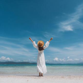 夏の青空と海、バカンスに来た女性の背中の写真