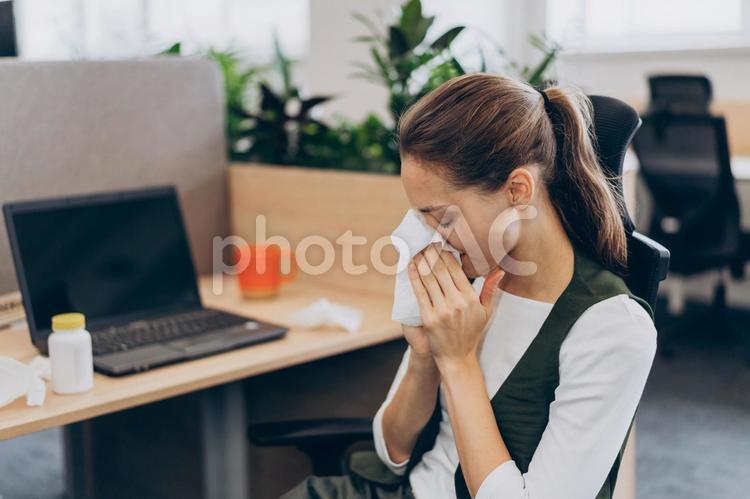 オフィスで鼻をかんでいる女性 コワーキング,ビジネス,女性の写真素材
