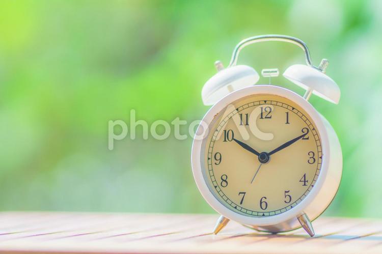 緑ぼかし背景と目覚まし時計 目覚まし時計,時間,時刻の写真素材