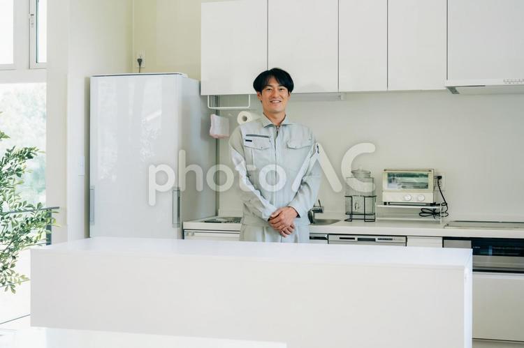 キッチンと作業着姿の男性 工務店,作業服,設備の写真素材
