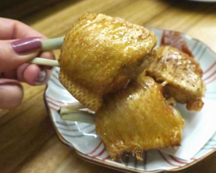 骨付きチキンの唐揚げを持つ女性 骨付きチキンの唐揚げを持つ女性の写真