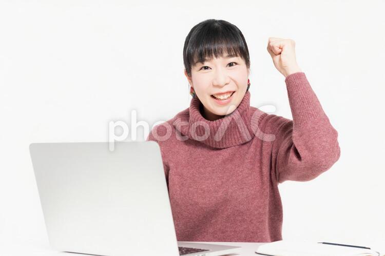 ノートパソコンを使いながらガッツポーズをする女性 女性,パソコン,ノートパソコンの写真素材