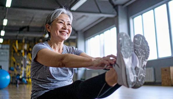 前屈のストレッチをするシニア女性 前屈のストレッチをするシニア女性の写真