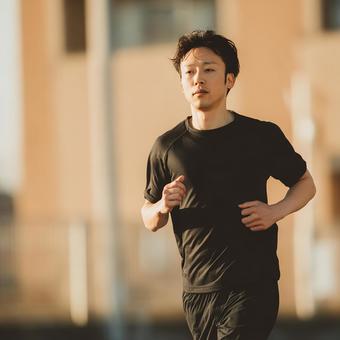 ランニングウェアを着てさわやかに走る男性 ランニングウェアを着てさわやかに走る男性の写真