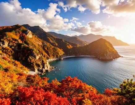 空と太陽、そして海と紅葉している山々 空と太陽、そして海と紅葉している山々の写真