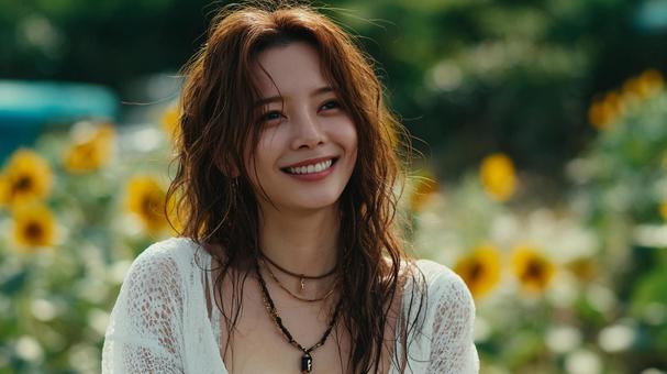 向日葵畑で笑顔を見せる日本人女性の写真