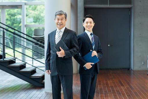 オフィスの廊下を歩くビジネスパーソン オフィスの廊下を歩くビジネスパーソン ビジネスマン,笑顔,ビジネスパーソンの写真素材