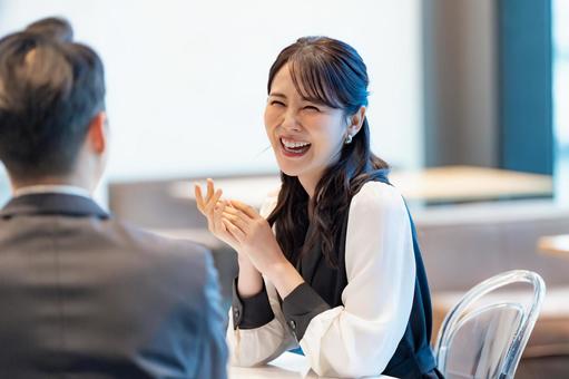 室内で大きく笑って話す女性 笑顔,会話,打ち合わせの写真素材