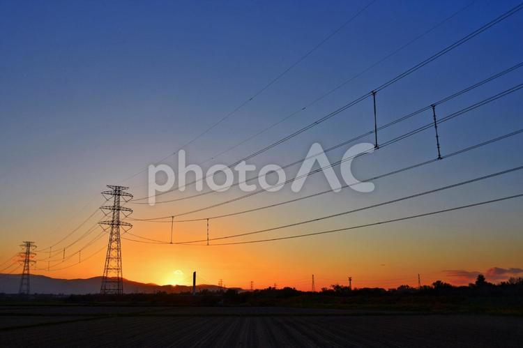 夕陽と鉄塔と送電線 エコロジー,エネルギー,オレンジの夕陽の写真素材
