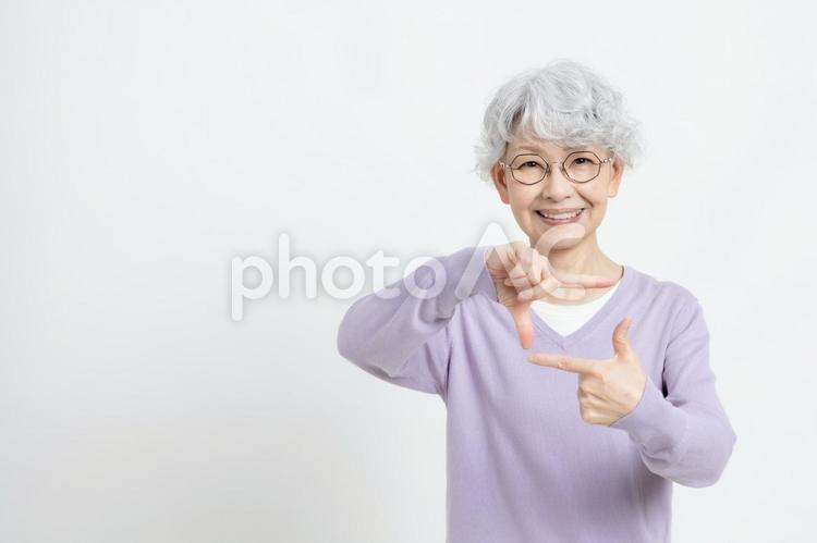 写真を撮るポーズをするシニア女性 女性,シニア,グレイヘアーの写真素材